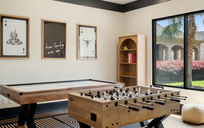 a room with a shuffle board table and foosball